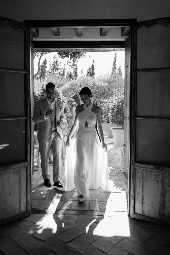Bride and groom walking in through a sunlit doorway at Casa La Siesta, Vejer, black and white